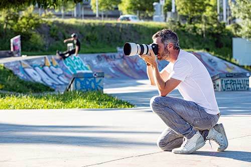 Seitenansicht eines Fotografes bei der Arbeit vor einer Skater Anlage