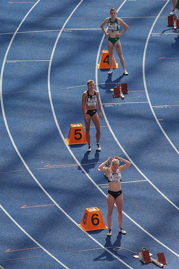 Startvorbereitungen zum 400m Lauf der Frauen. Die tief stehende Sonne zeichnet die Dachkonstruktion des Olympiastadions schon deutlich auf die Laufbahn.
